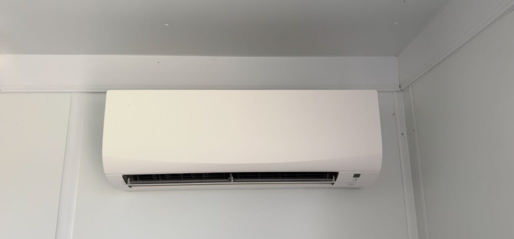 A white ductless mini-split heat pump mounted on an interior wall, providing efficient heating and cooling for the room.